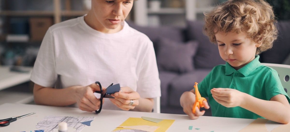 a boy and a boy are making crafts together