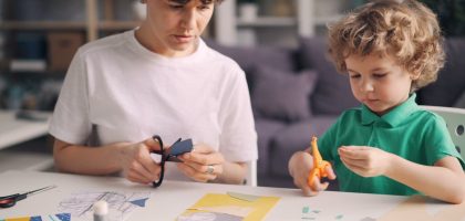 a boy and a boy are making crafts together