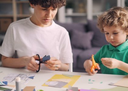 a boy and a boy are making crafts together