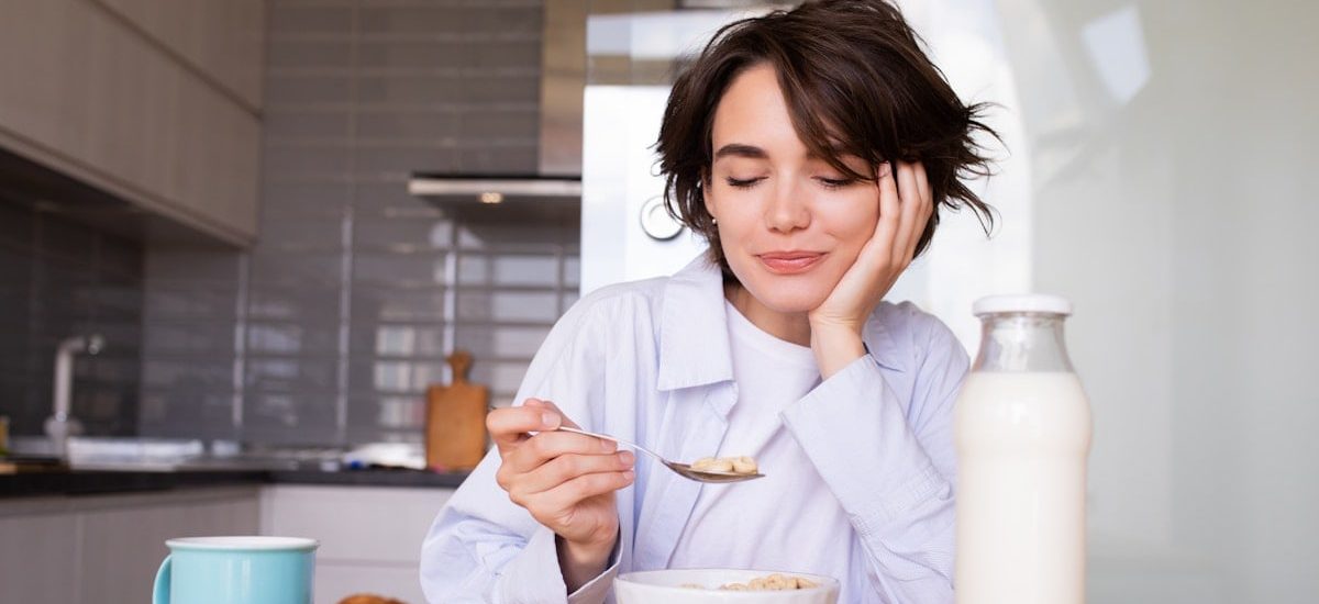a woman sitting at a table with a plate of food